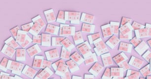 a pile of pink and white squares on a pink background