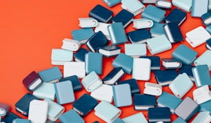 a pile of blue and white cell phones on an orange background