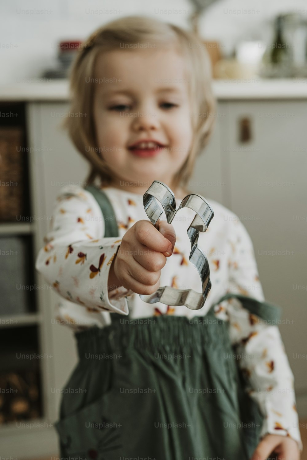 Una niña pequeña sosteniendo un par de tijeras en la mano
