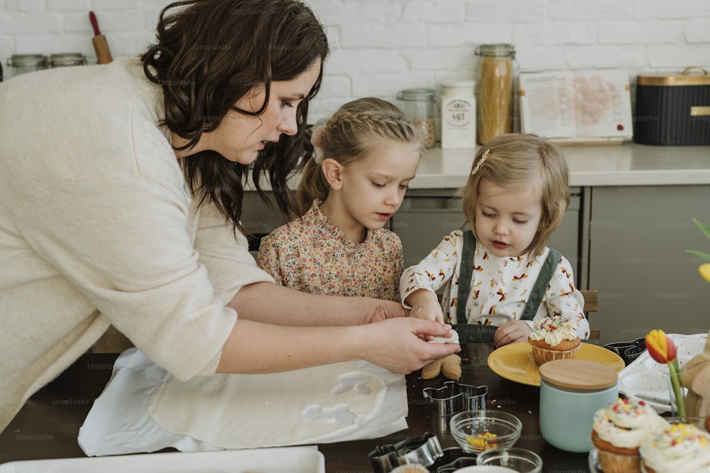 Eine Frau und zwei Kinder backen Cupcakes