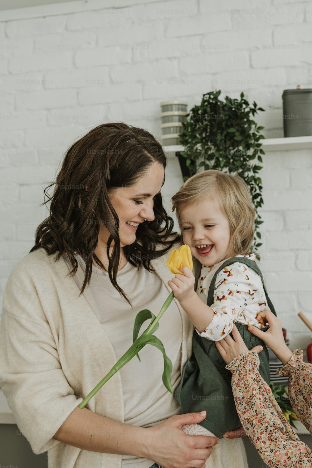 a woman and a little girl holding a flower