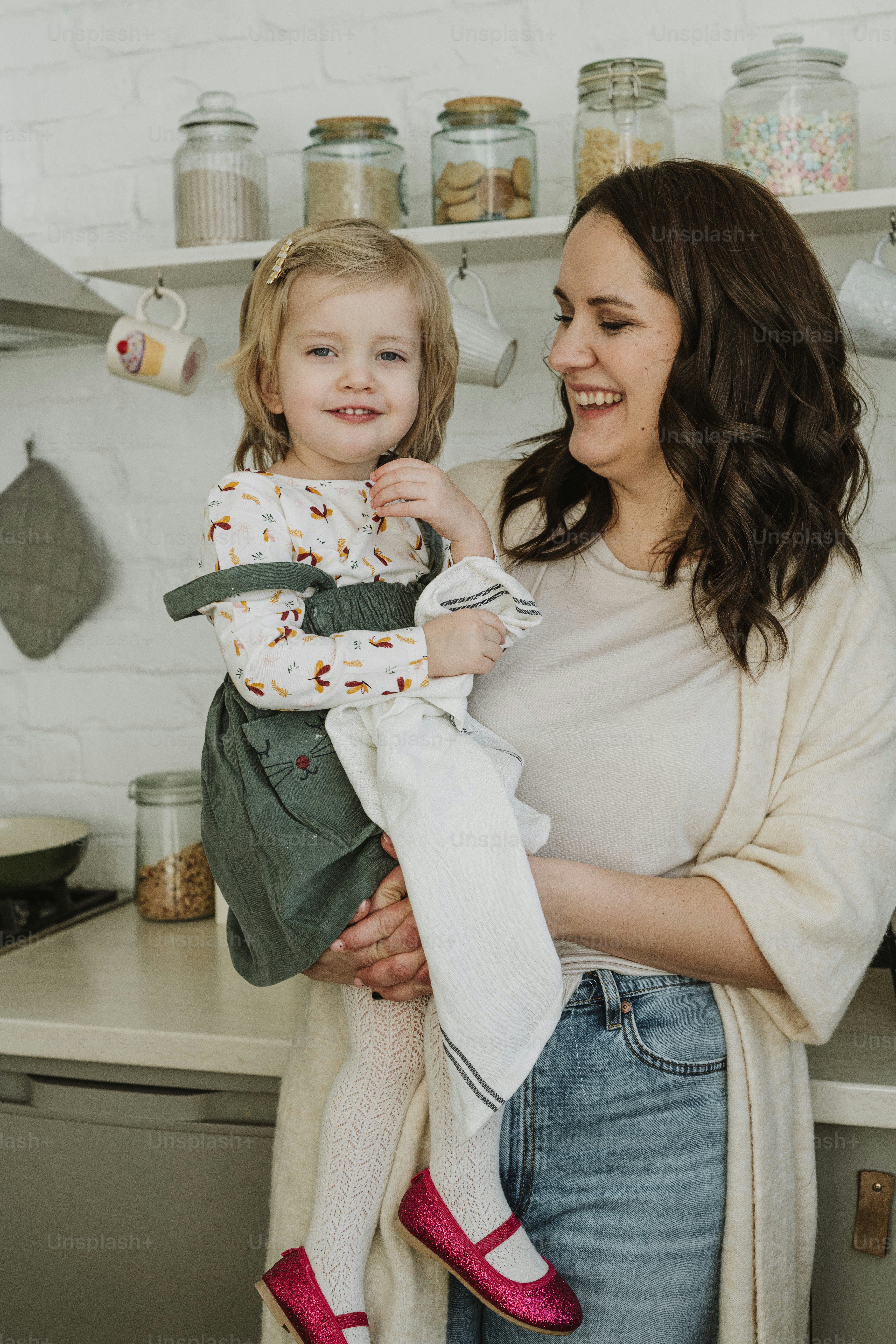 어린 소녀를 팔에 안고 있는 여자