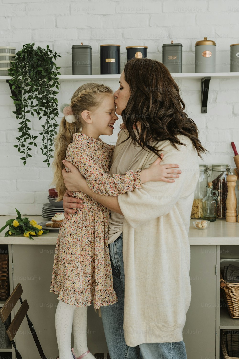 a mother hugging her daughter in the kitchen