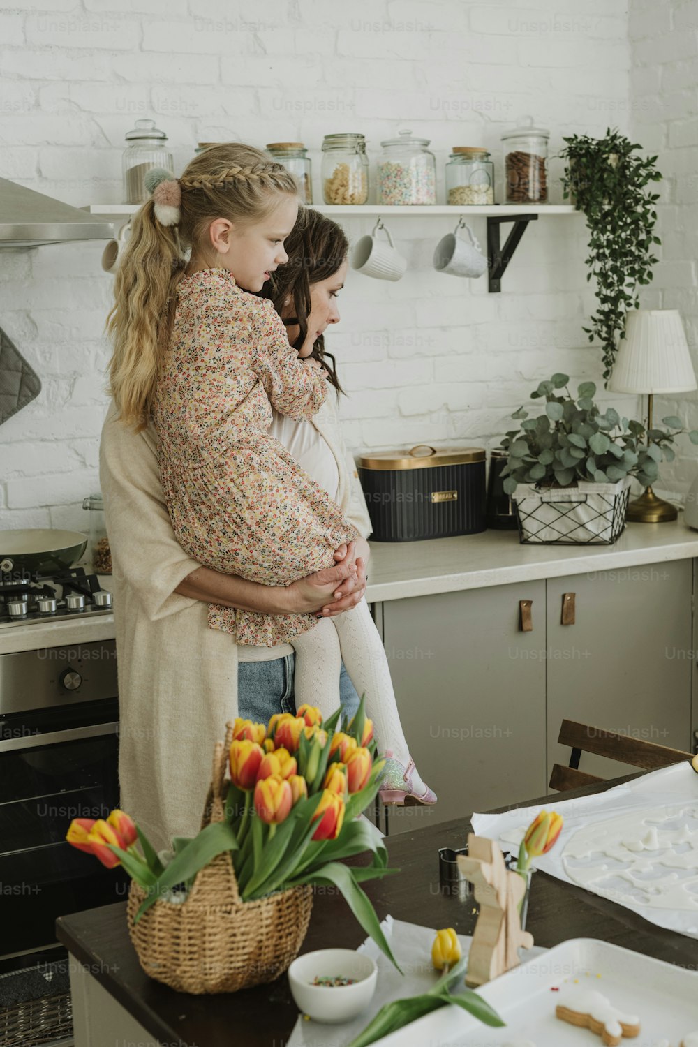 Una mujer sosteniendo a un niño en una cocina