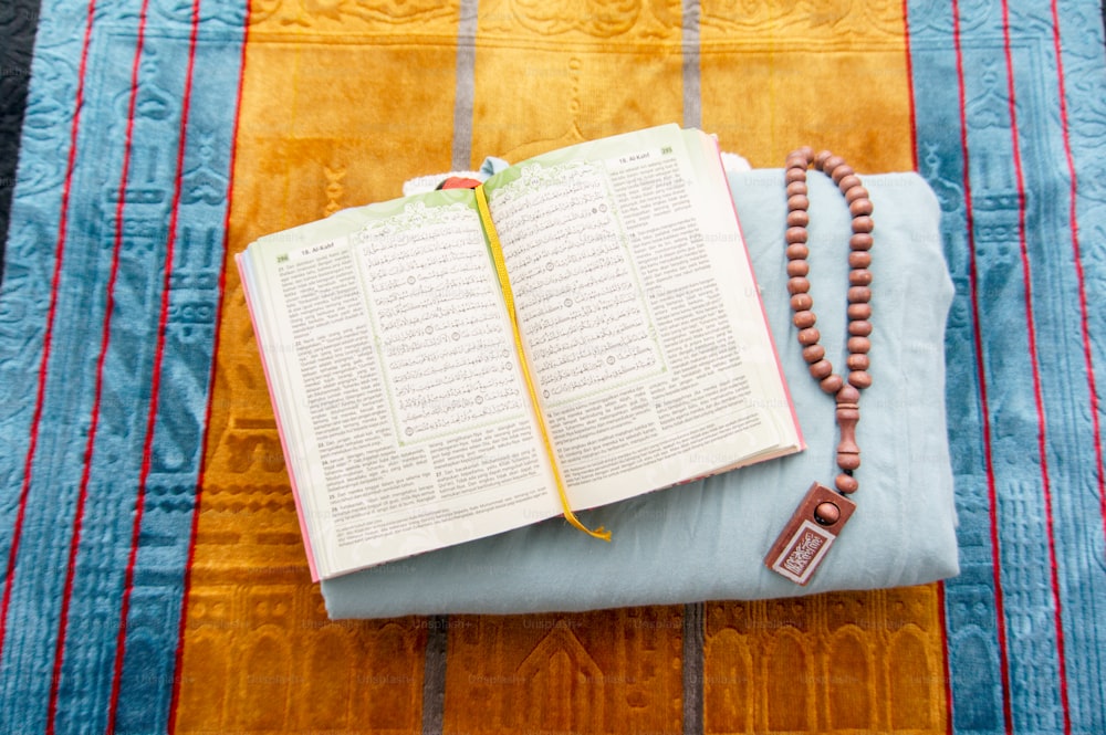 Un rosario y un libro en una cama