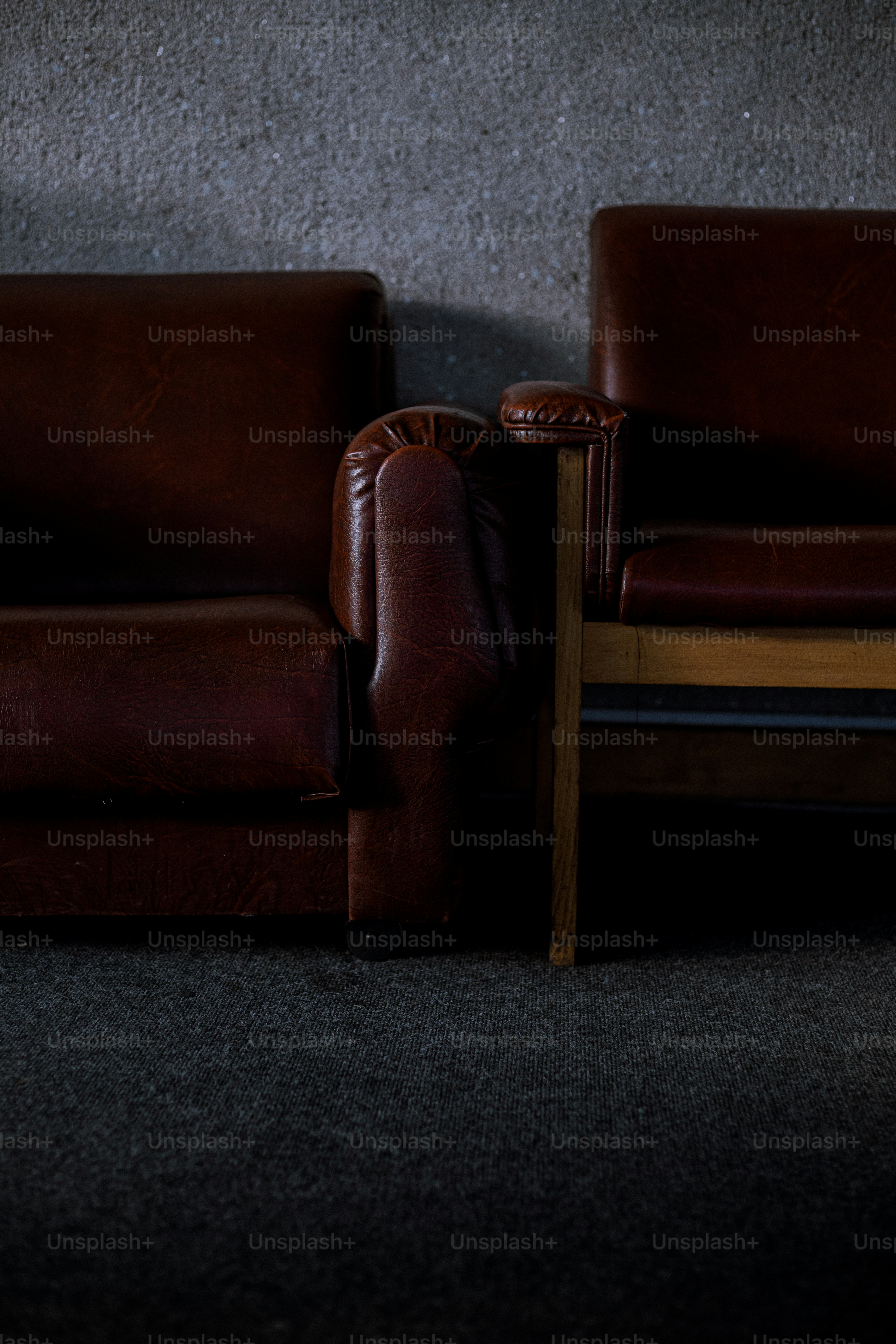 a brown leather couch sitting next to a wooden table