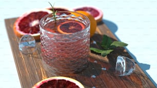 a glass filled with blood oranges sitting on top of a wooden cutting board