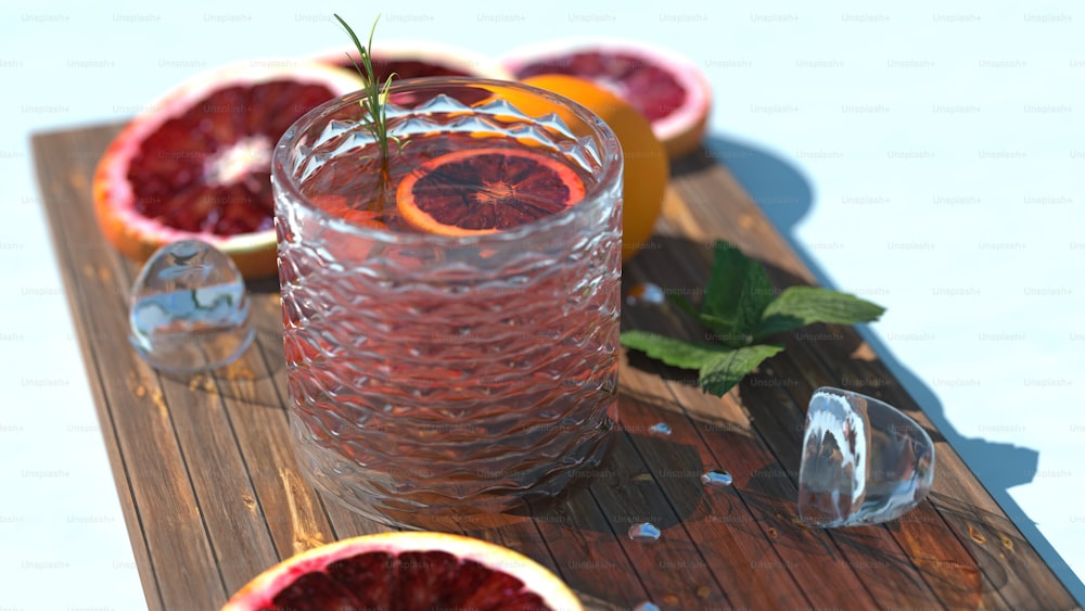 a glass filled with blood oranges sitting on top of a wooden cutting board