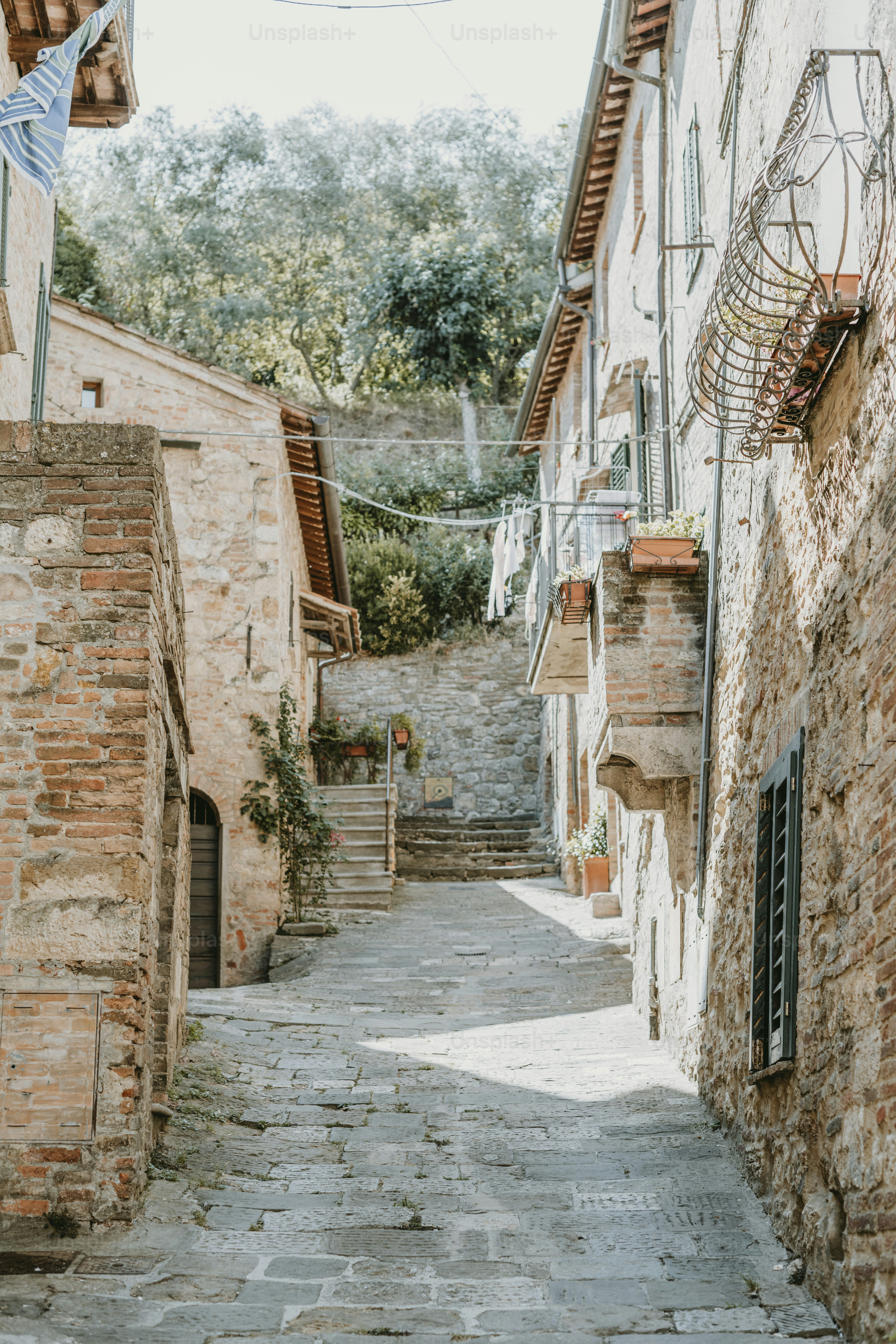 une ruelle étroite avec des bâtiments en pierre et un drapeau bleu