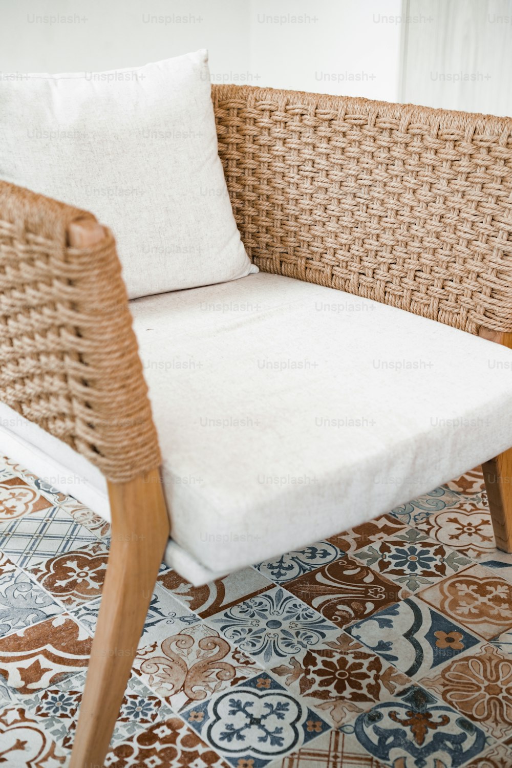 a wicker chair with a white pillow on top of it