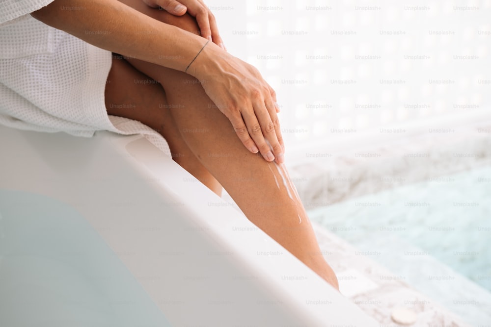 a woman sitting in a bathtub with her legs crossed