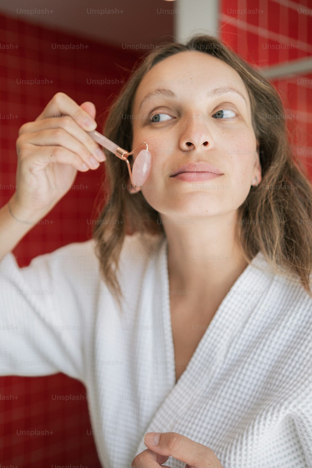 a woman in a bathrobe brushing her teeth