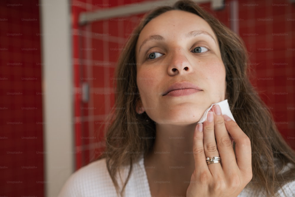 a woman in a white shirt is looking at the mirror