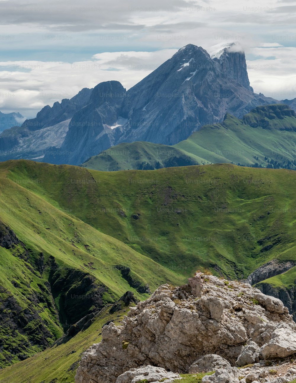 a mountain range covered in green grass and rocks