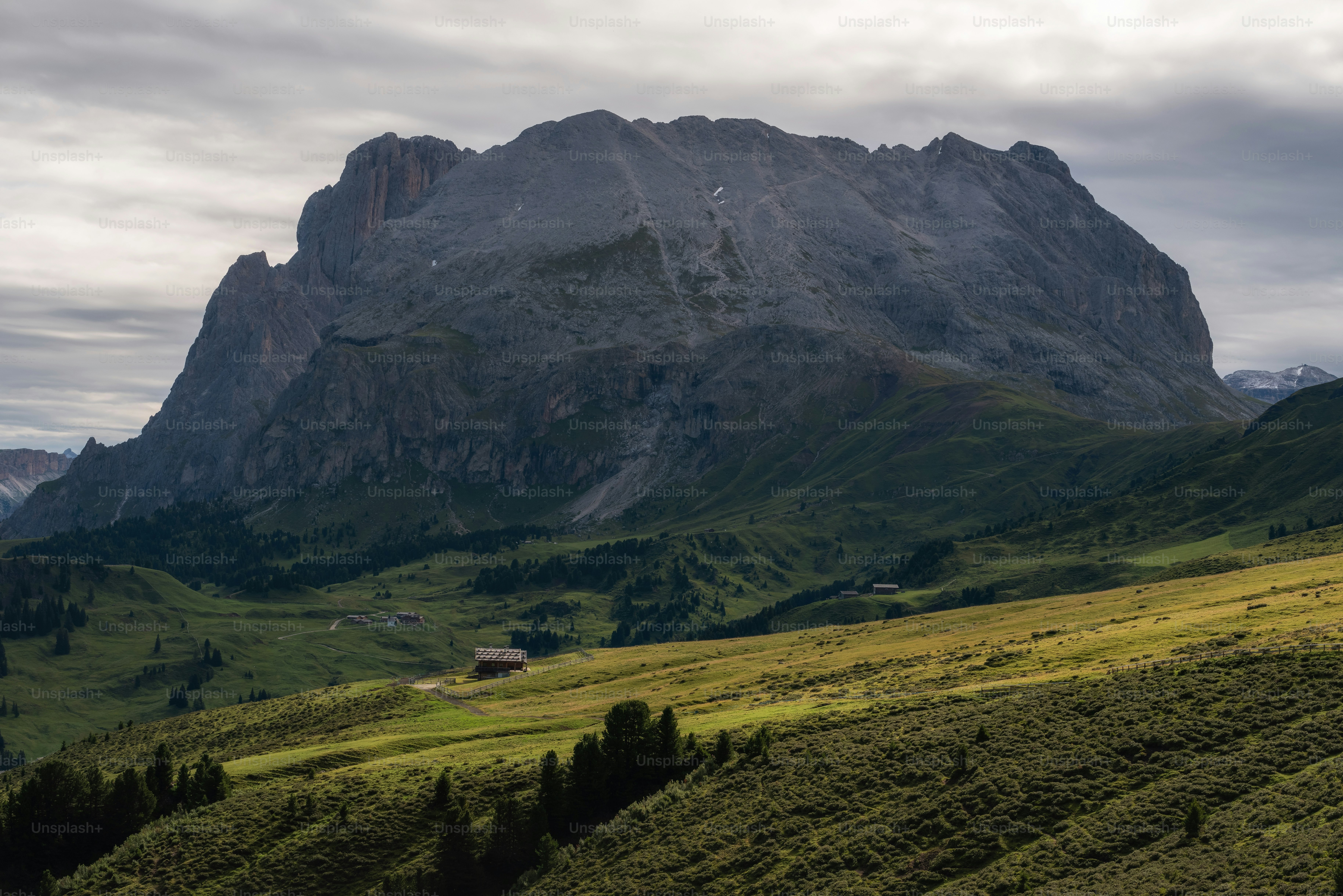 a mountain range with a house in the foreground