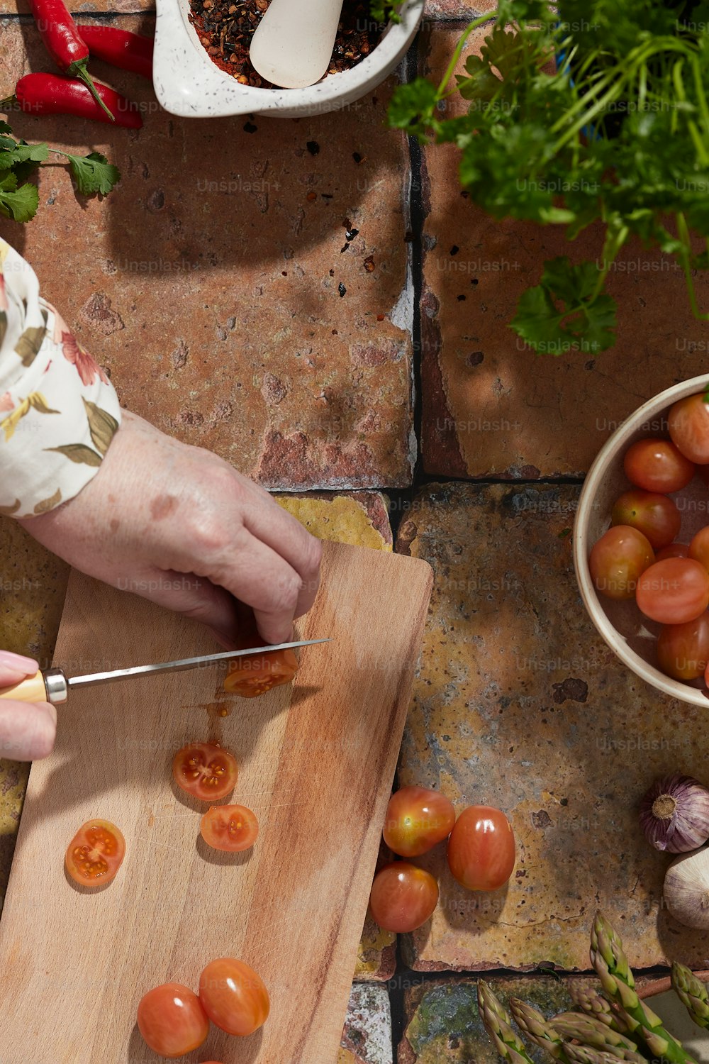 Una persona cortando tomates en una tabla de cortar
