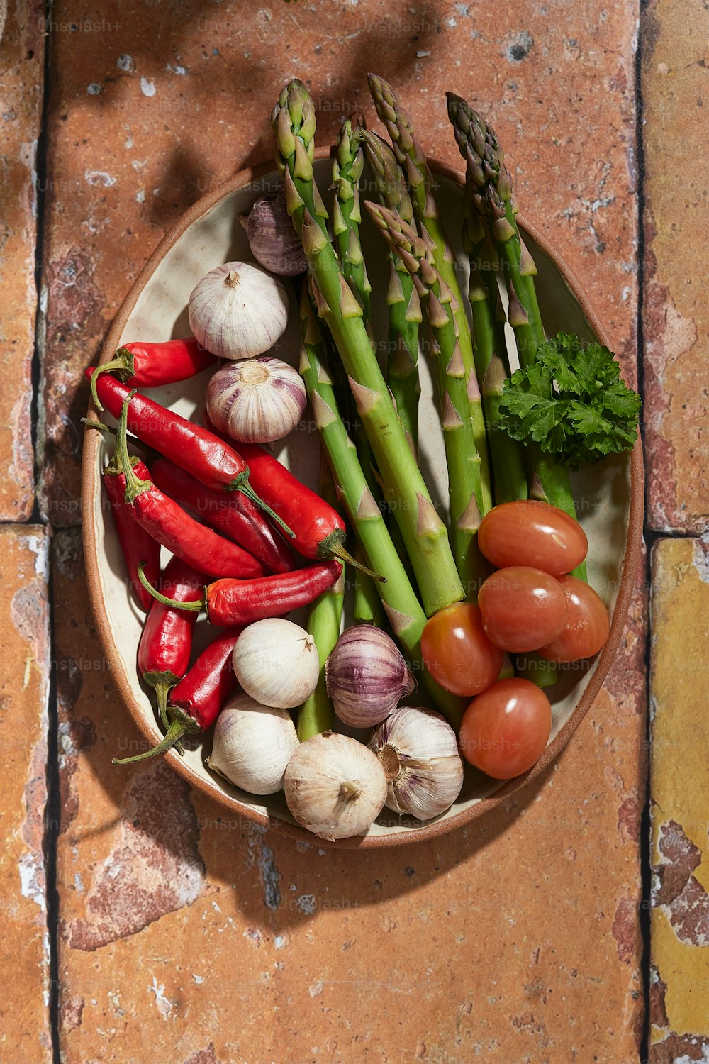 a plate with asparagus, tomatoes, asparagus, and other vegetables