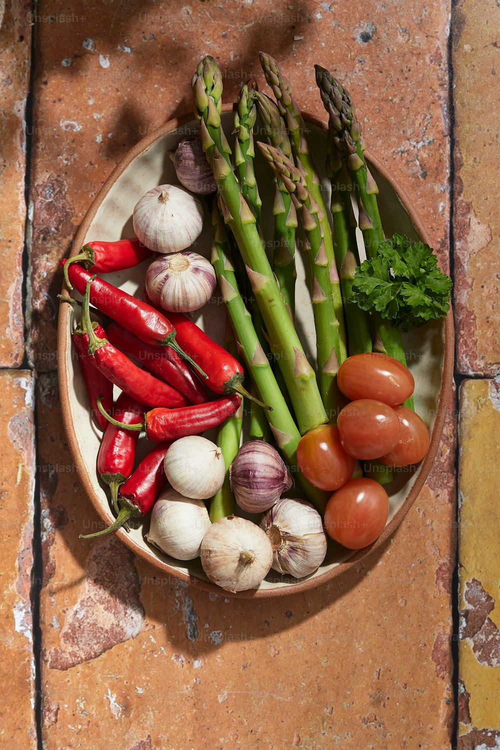 Un plato con espárragos, tomates, espárragos y otras verduras