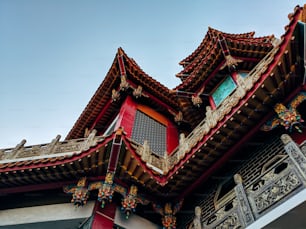 a red and gold building with a clock on it's side