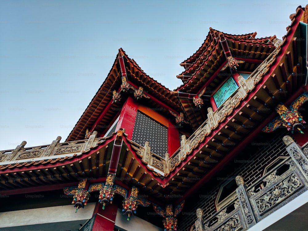 a red and gold building with a clock on it's side