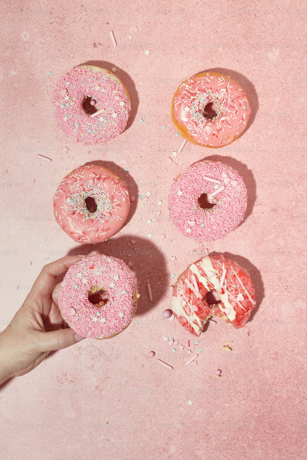 a person holding a doughnut with sprinkles on it