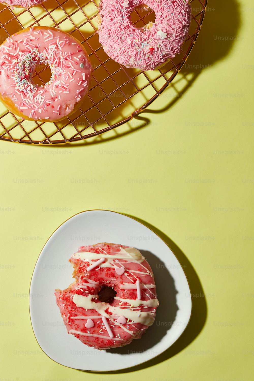 um par de donuts sentados em cima de um prato branco