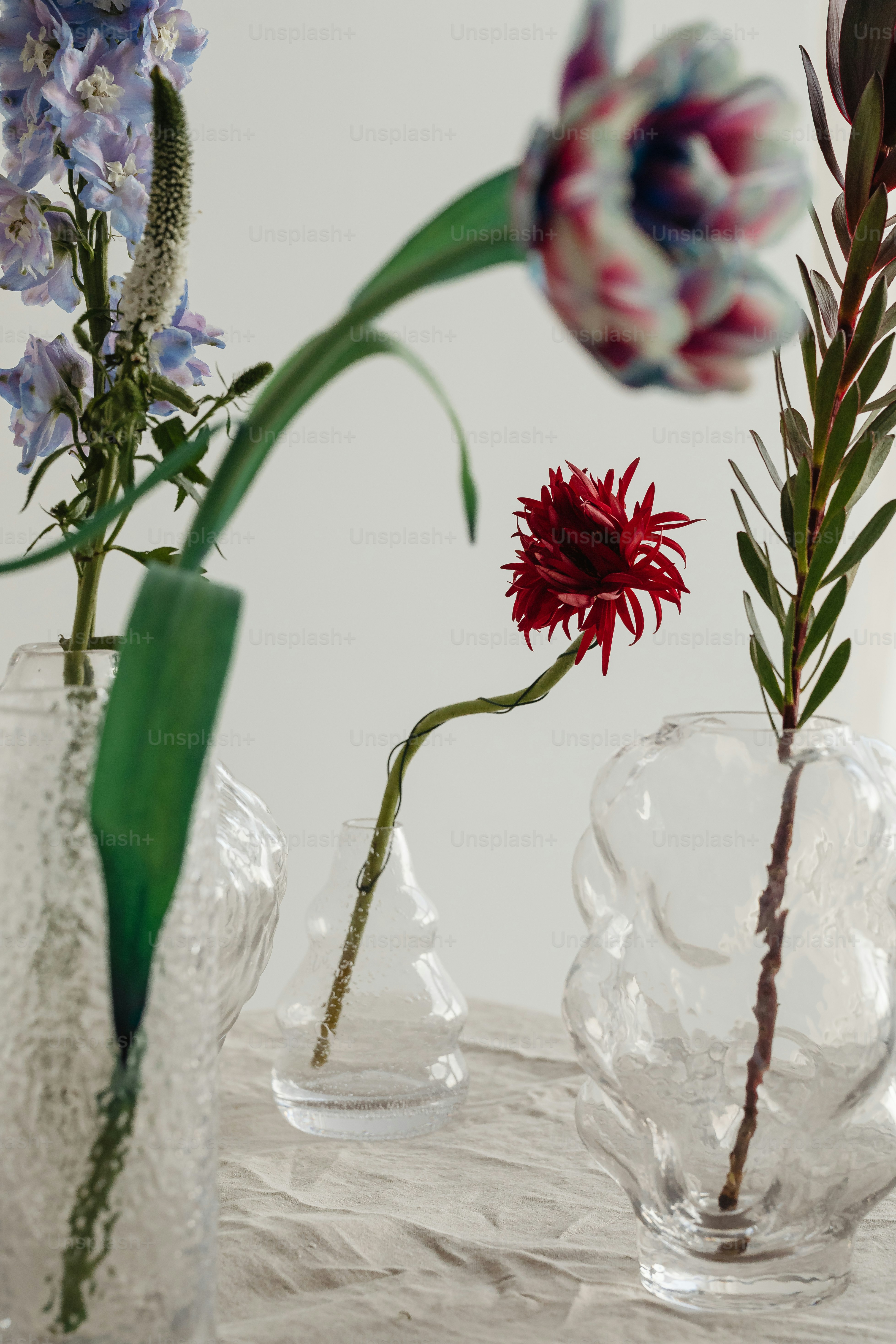 テーブルの上に座っている花が入った3つの花瓶