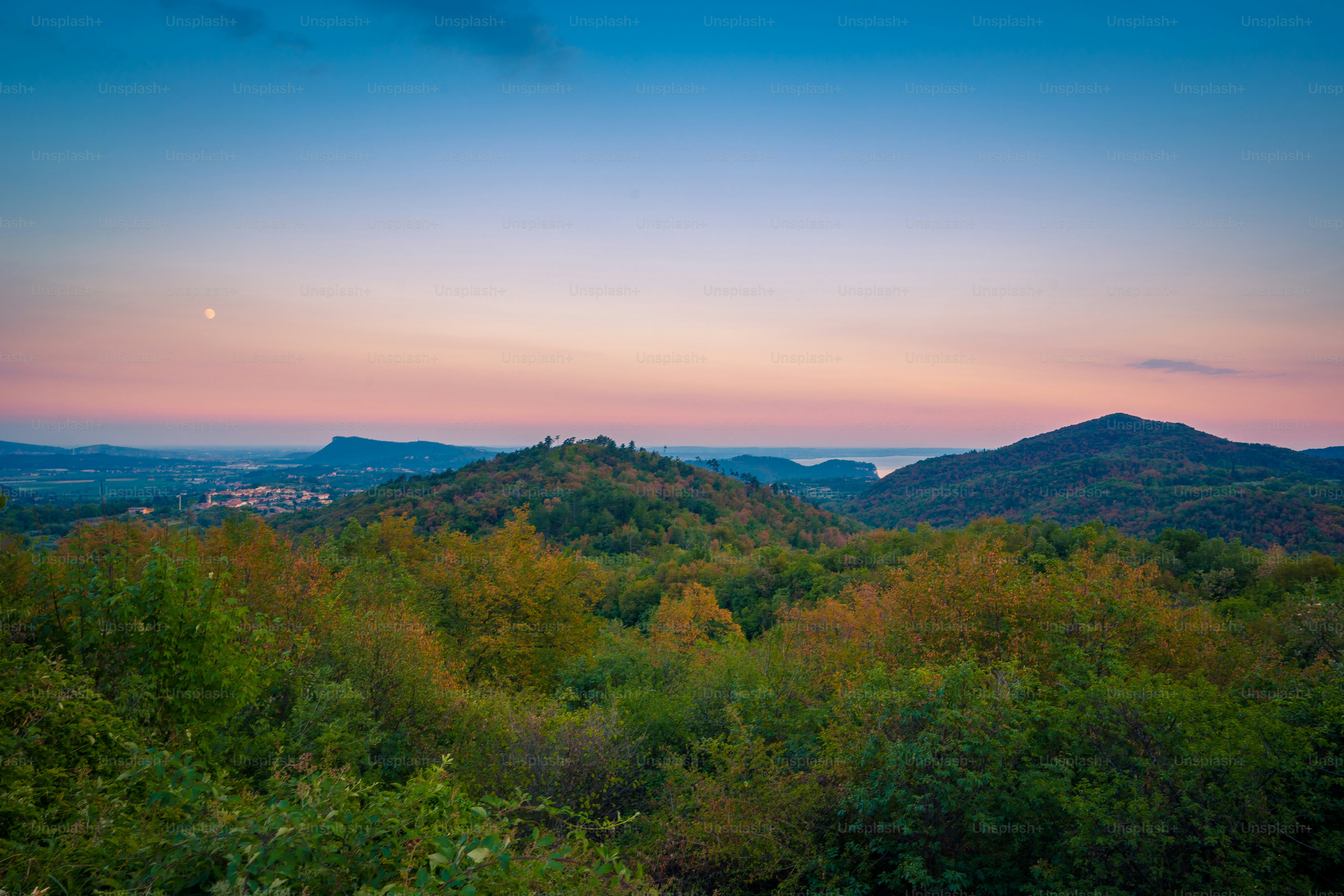 the sun is setting over the mountains in the distance