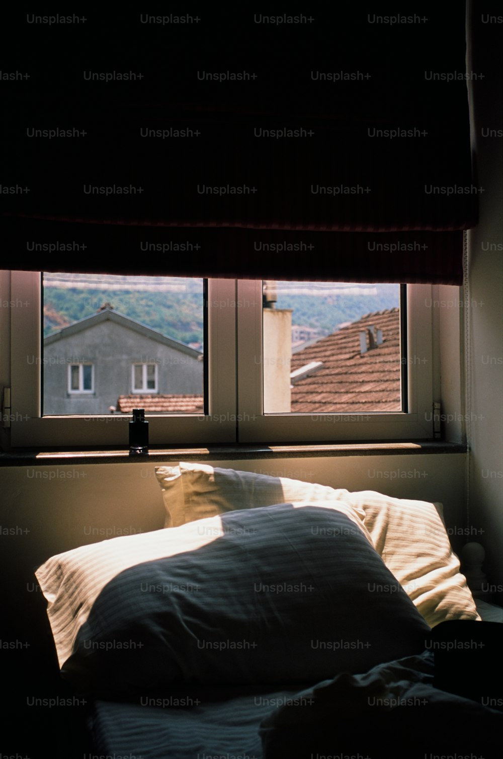 uma cama sentada sob uma janela em um quarto