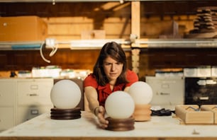 a woman sitting at a table with three eggs