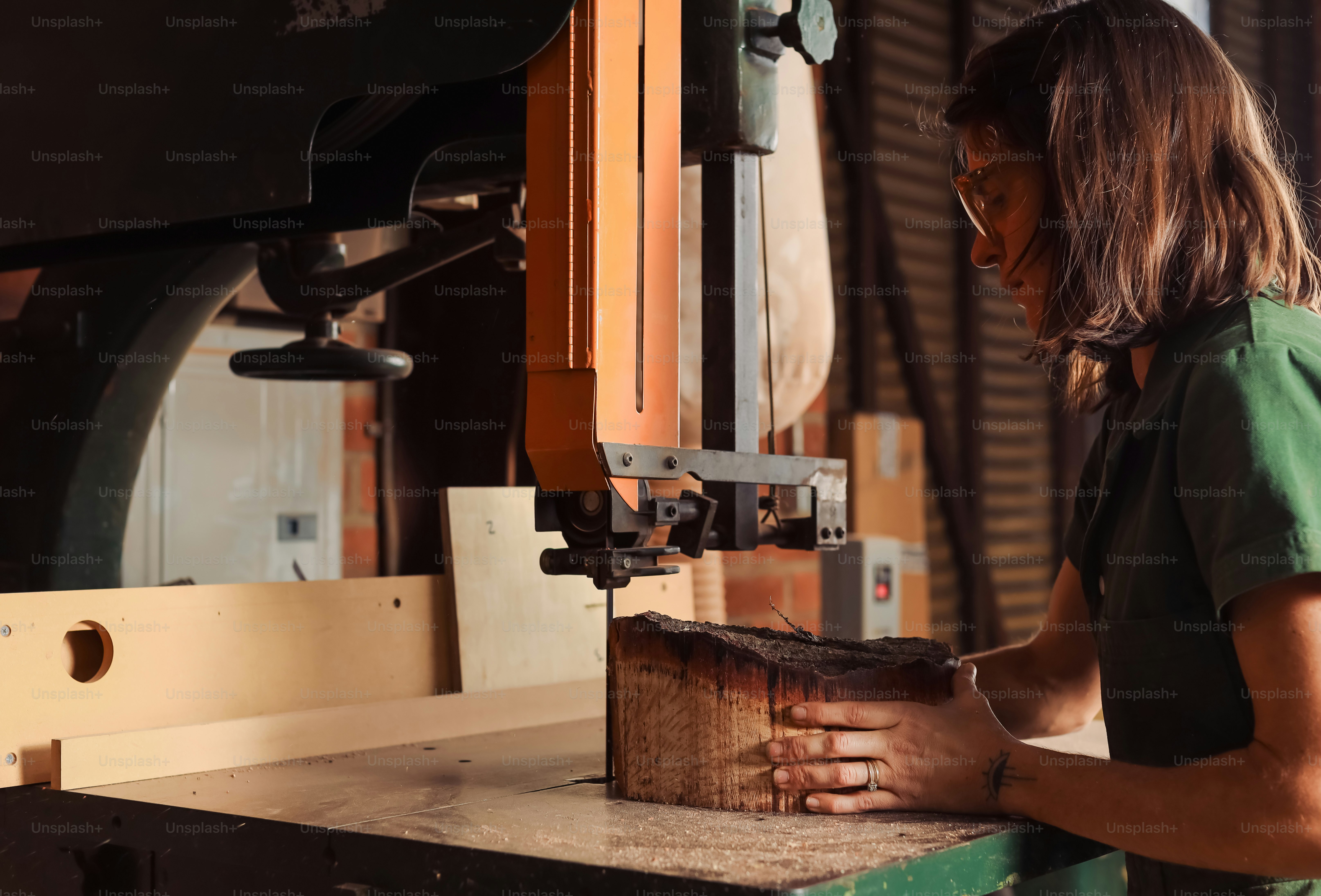 a woman in a green shirt working on a machine