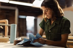 a woman sitting at a table working on a piece of paper