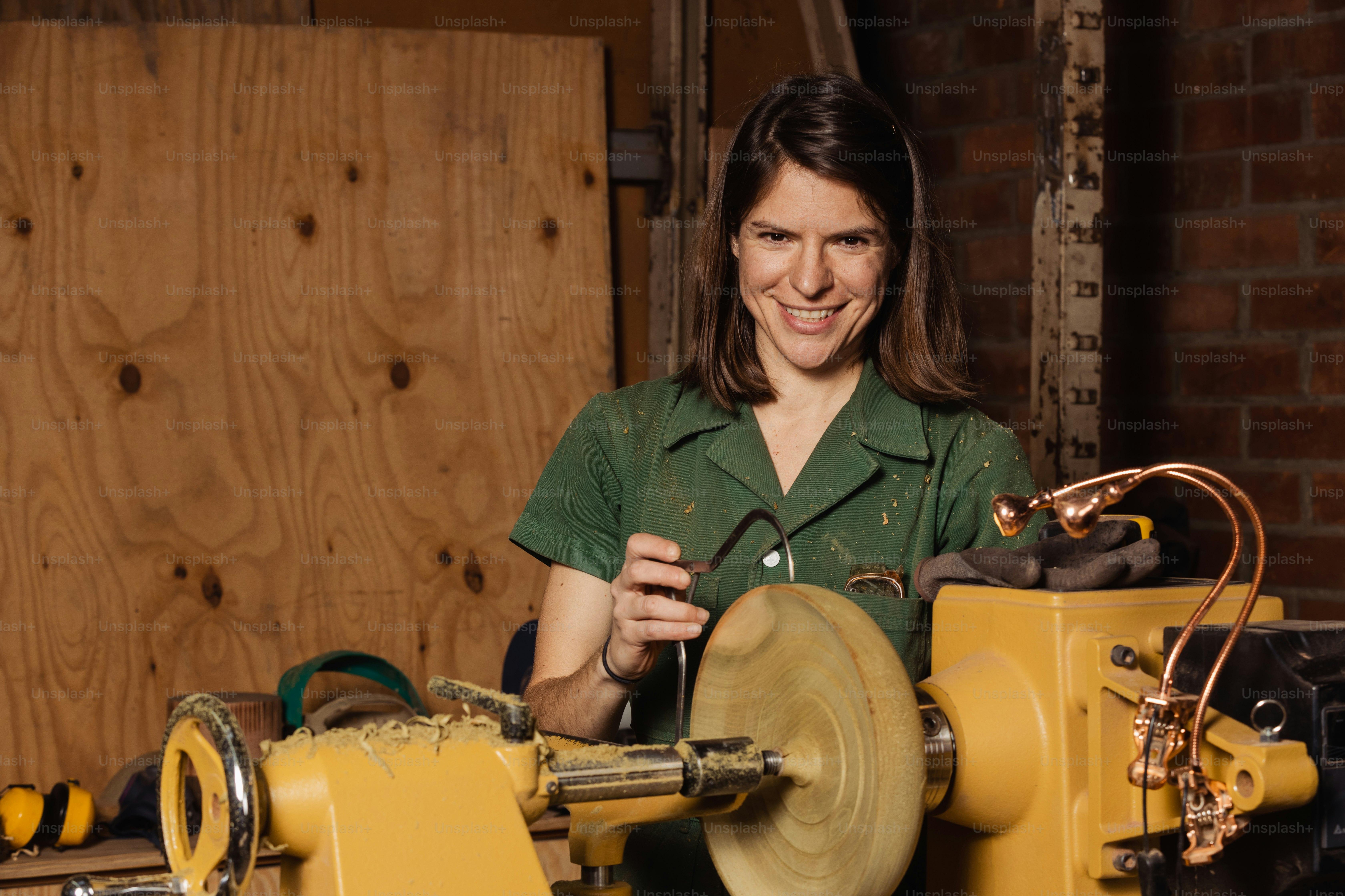 a woman in a green shirt working on a machine