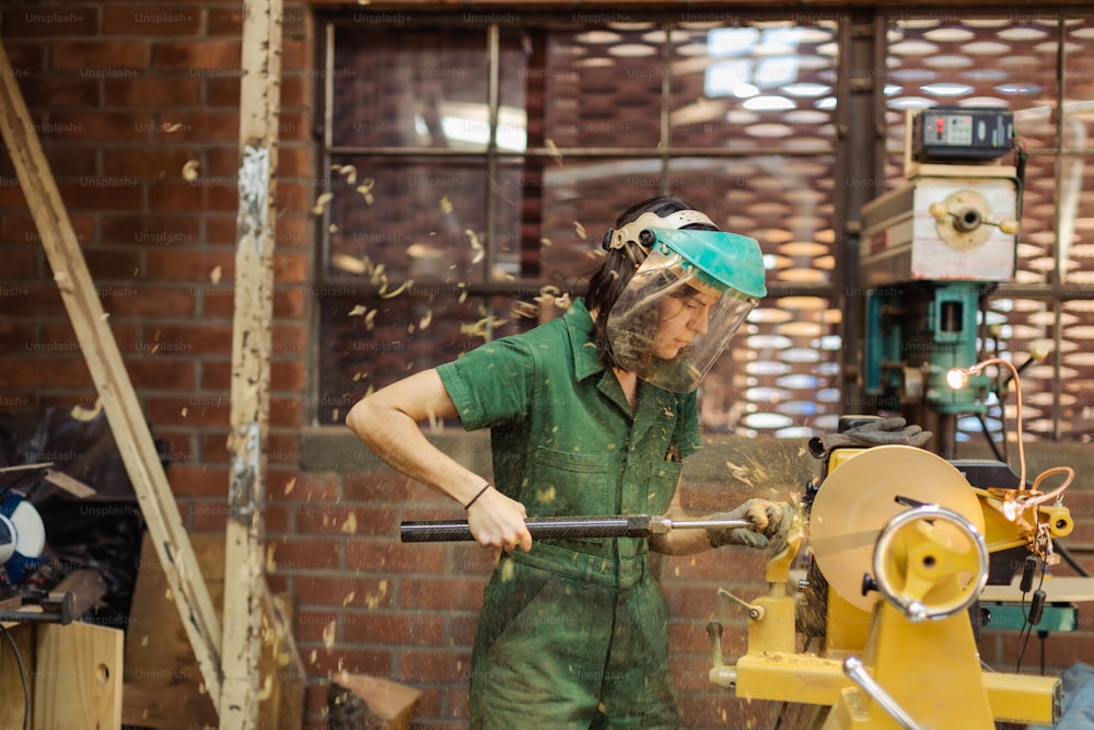 a man in green overalls working on a machine