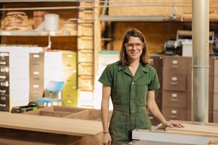 Una mujer con una camisa verde de pie junto a una caja