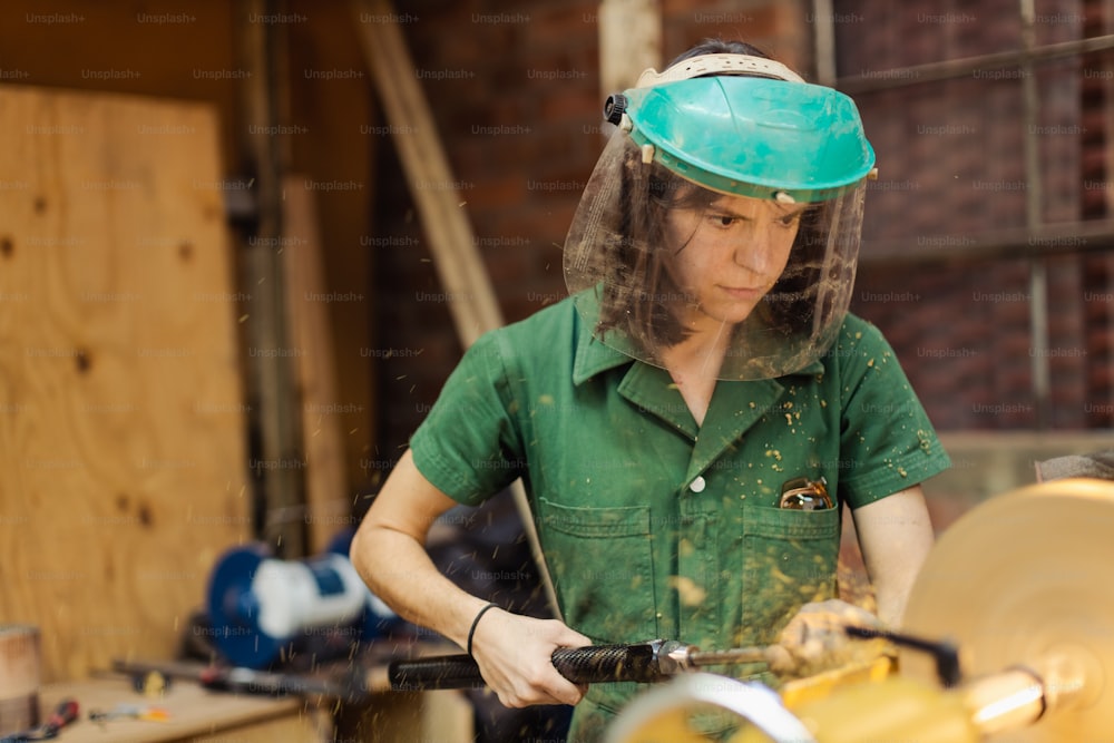 Una mujer con casco trabajando en una máquina