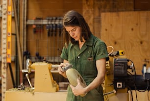 uma mulher em uma camisa verde que trabalha em um pedaço de madeira