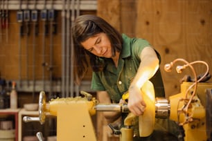 a woman in a green shirt working on a machine