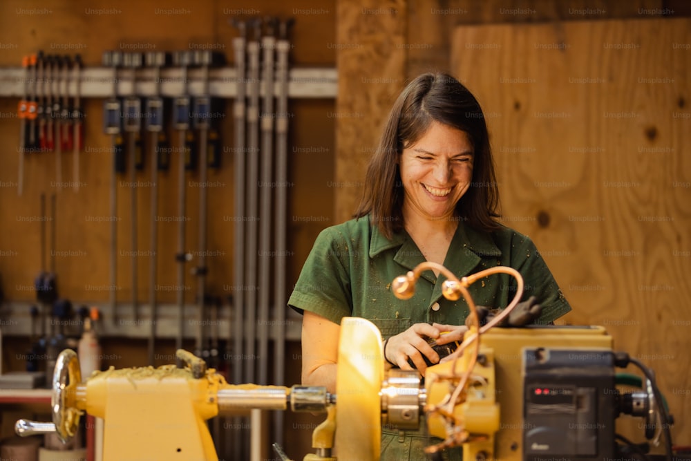 a woman in a green shirt working on a machine