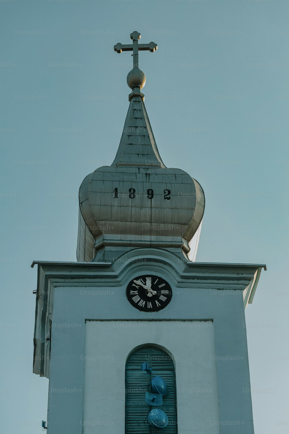 una torre dell'orologio con una croce in cima