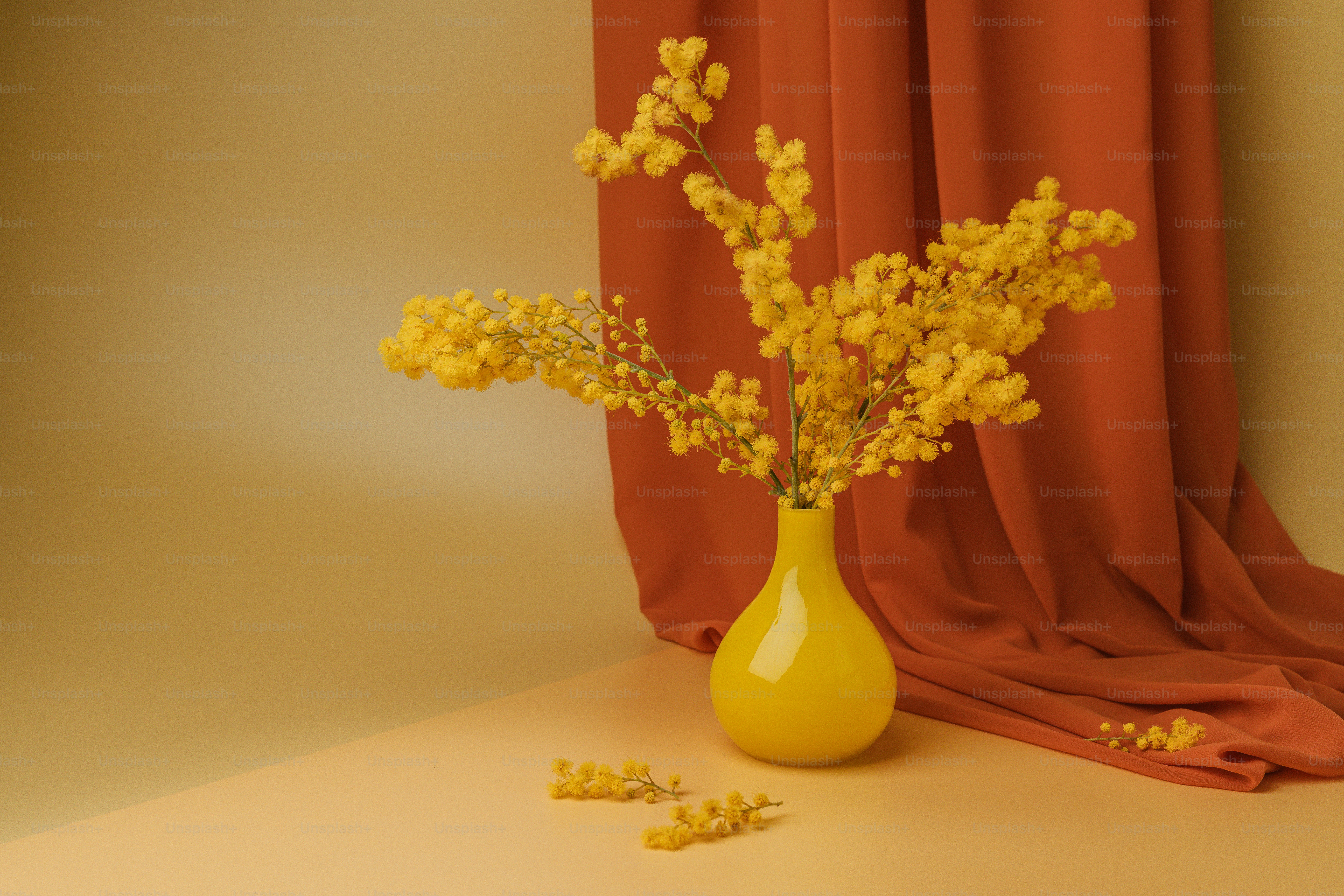A yellow vase filled with yellow flowers on top of a table photo ...
