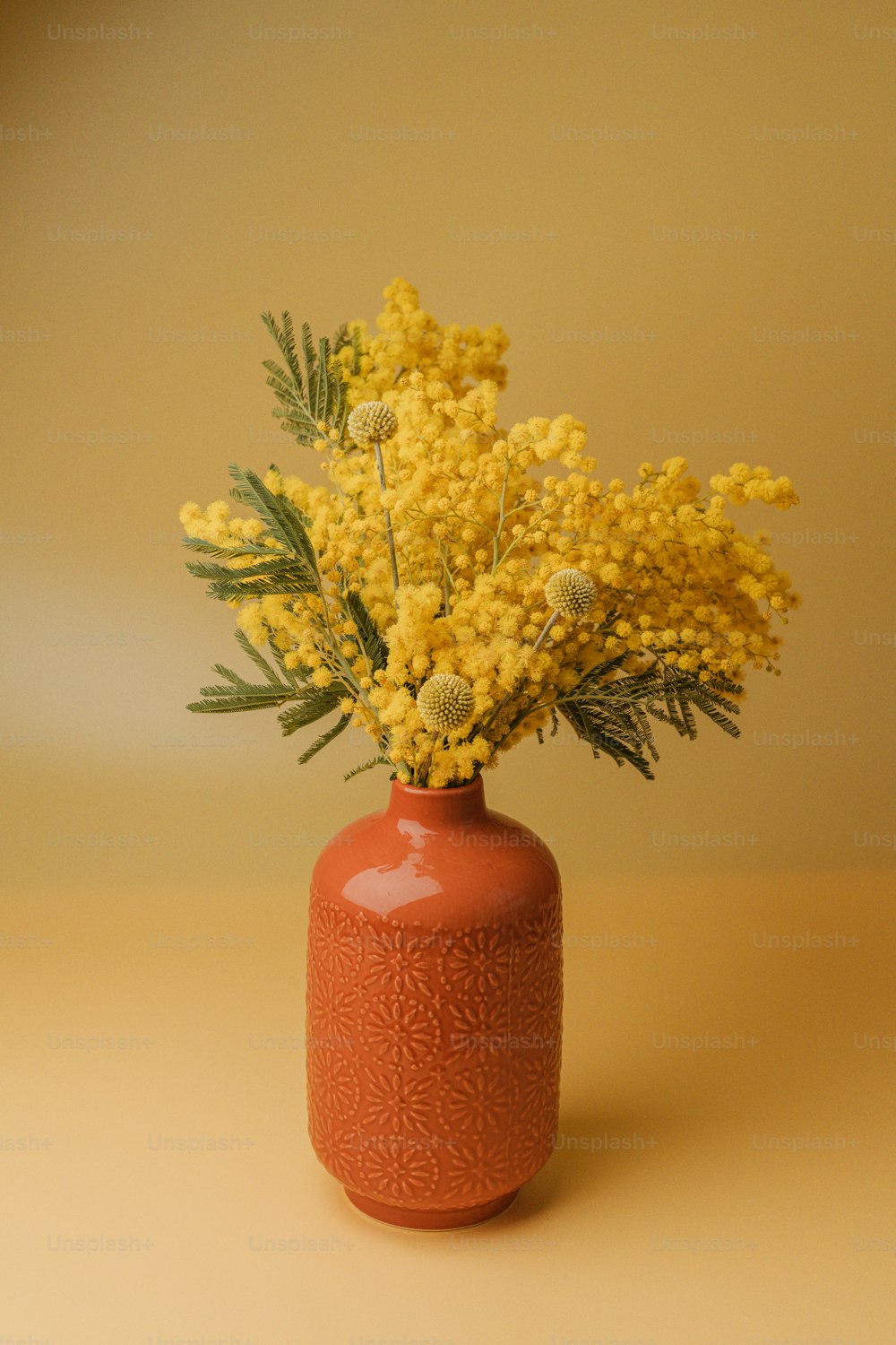 テーブルの上に黄色い花でいっぱいの花瓶