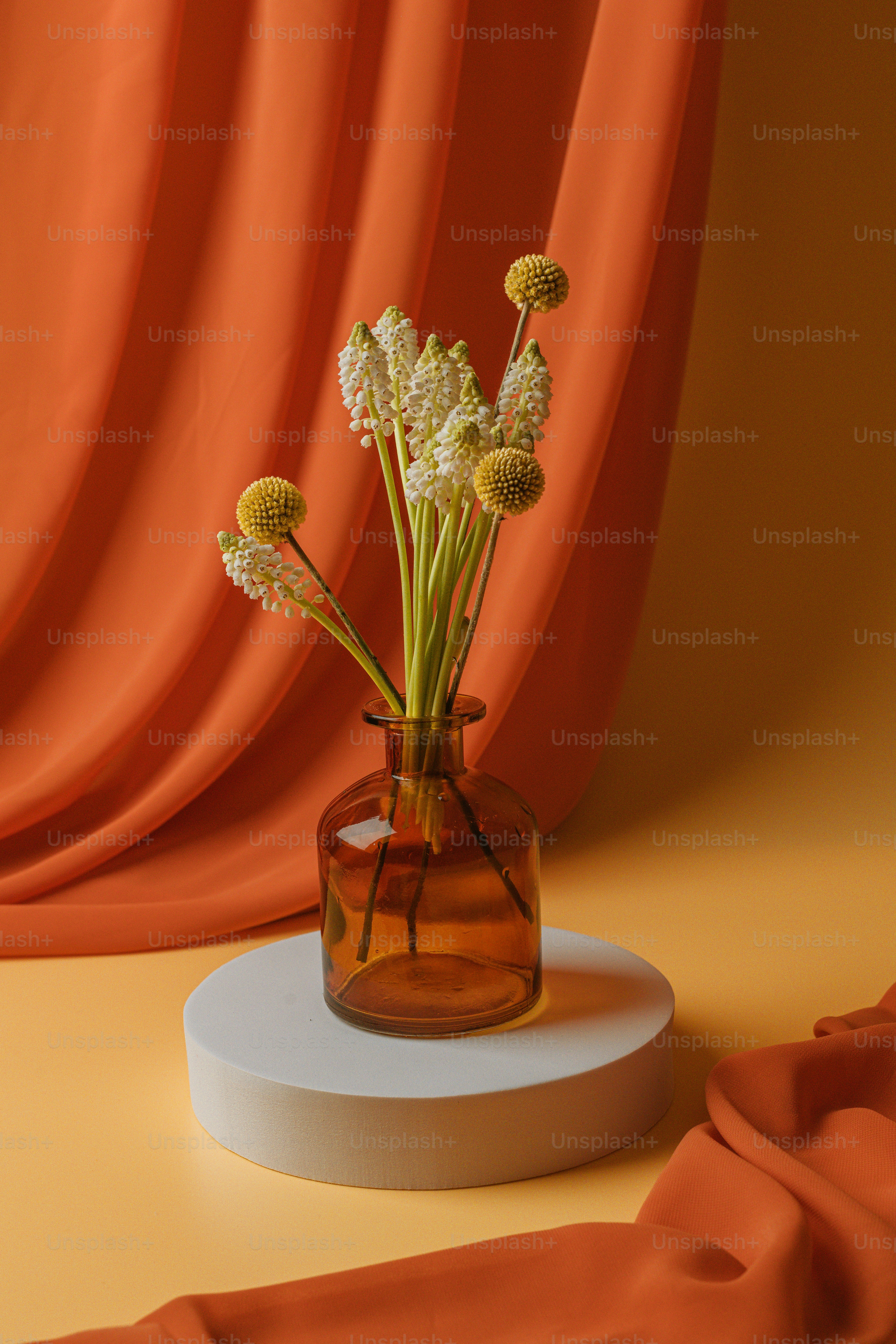 A yellow vase filled with yellow flowers on top of a table photo ...
