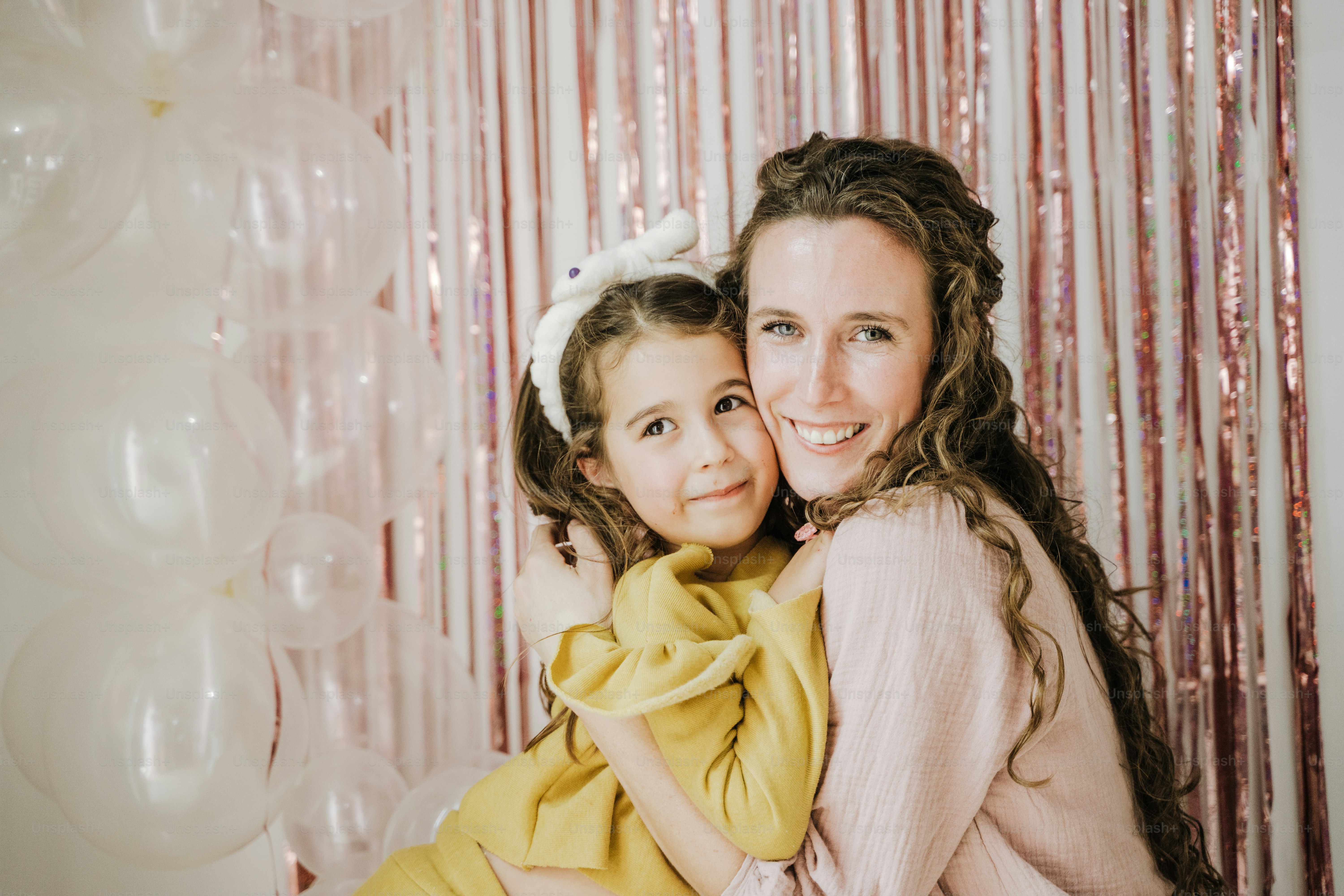 風船の前で抱き合う母と娘