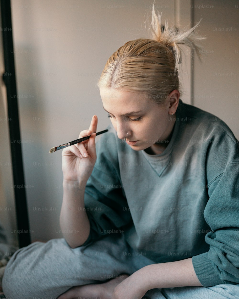 une femme assise sur un lit en fumant une cigarette