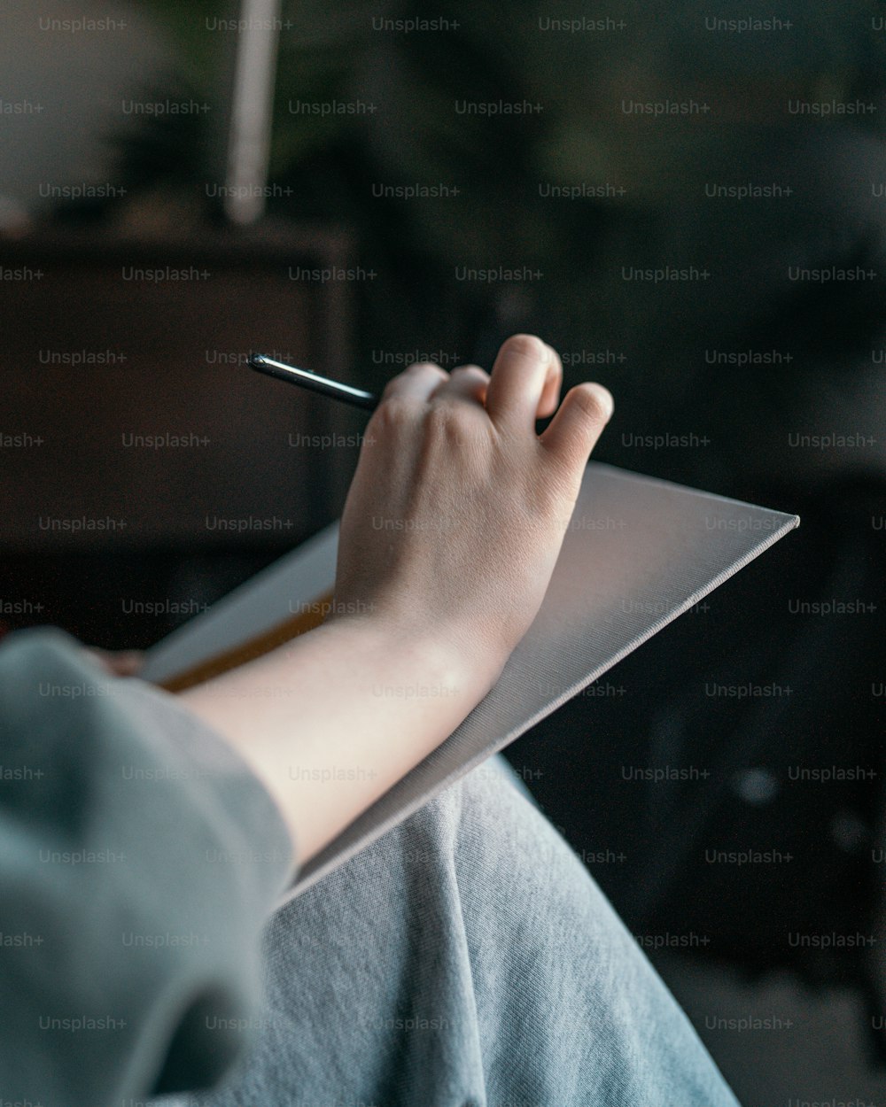 une personne tenant un stylo et écrivant sur un morceau de papier