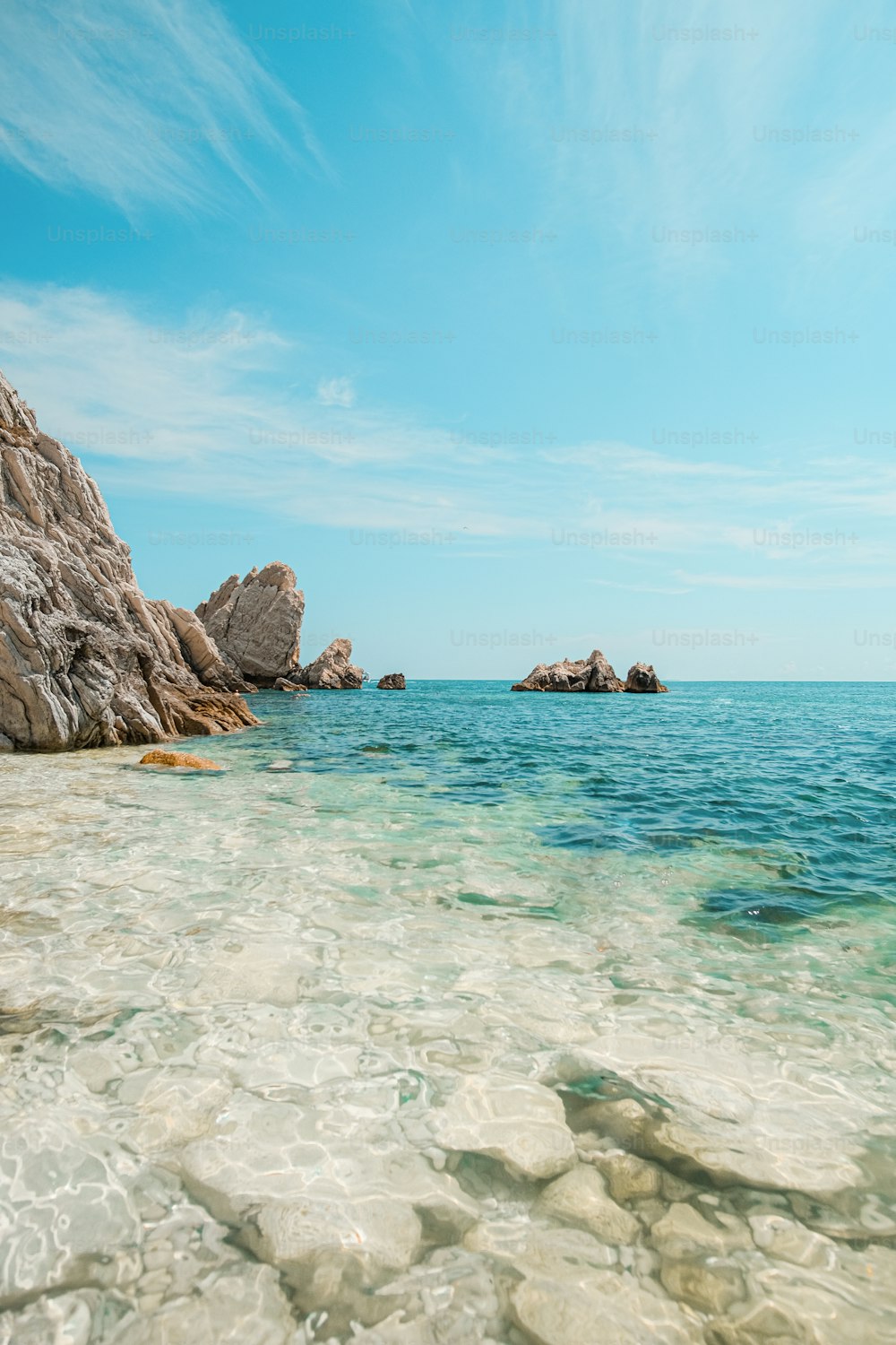 a body of water with rocks in the background