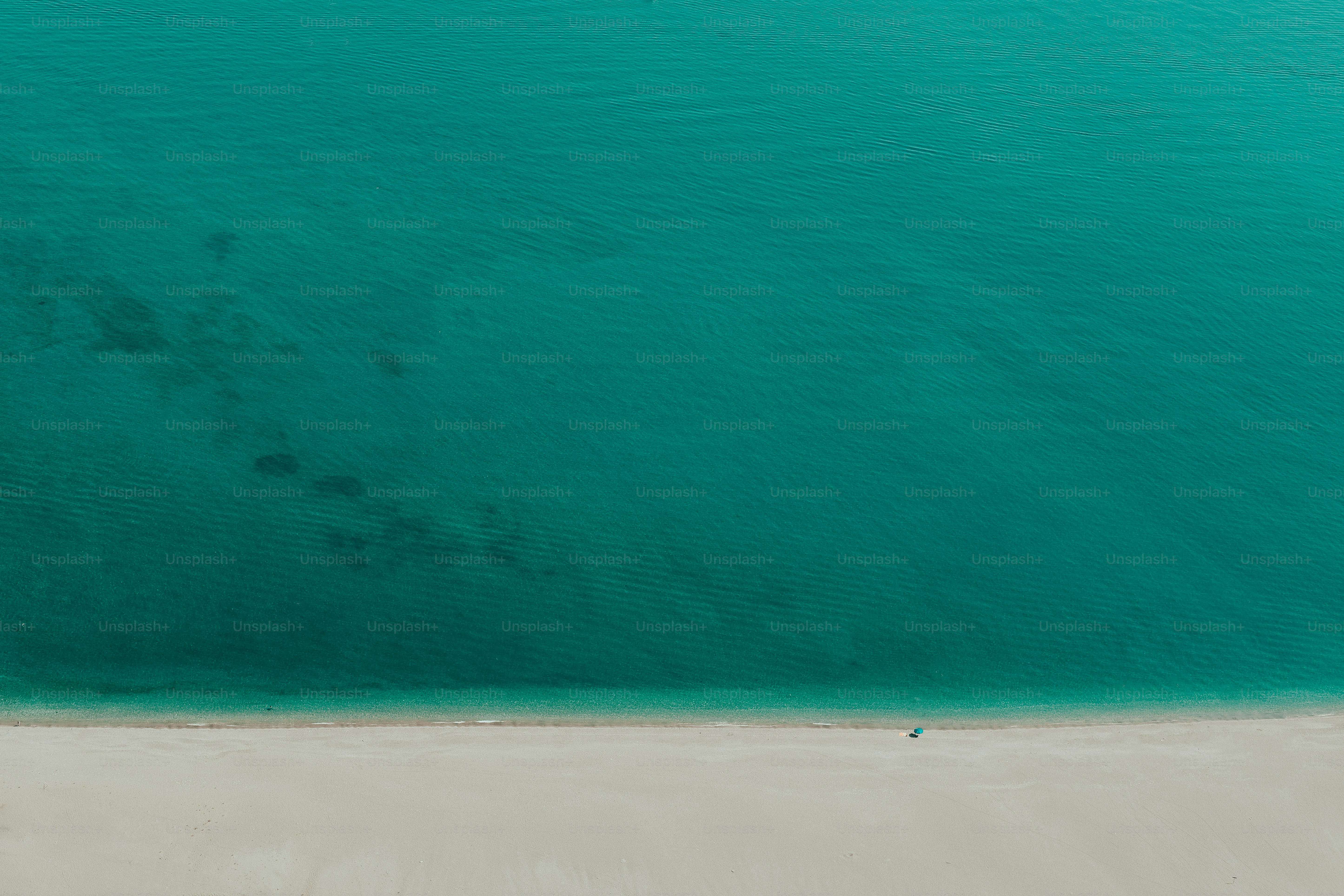 an aerial view of a beach with a boat in the water