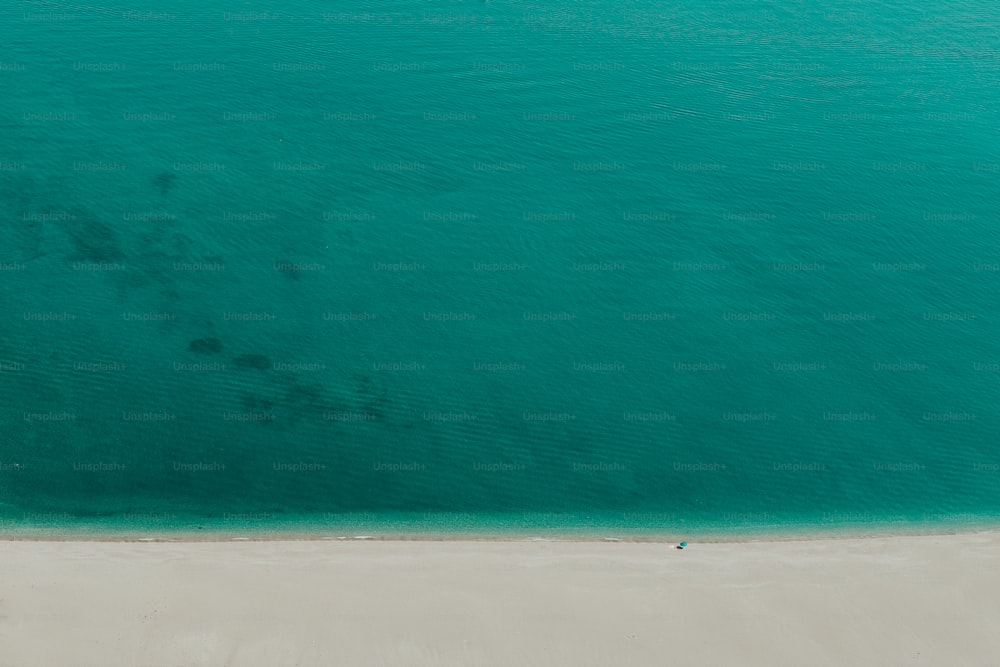 an aerial view of a beach with a boat in the water