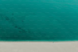 Una vista aérea de una playa con un barco en el agua